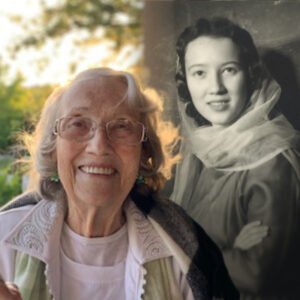 Smiling elderly woman with portrait of younger self.