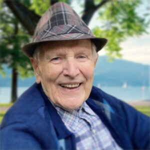 Smiling elderly man outdoors by a lake