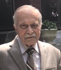 Elderly man in a suit outdoors near plants