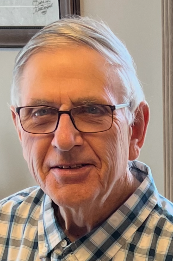 Elderly man wearing glasses and plaid shirt