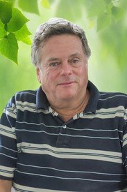 Man in striped shirt with leafy background