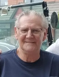 Smiling man with glasses near vintage car.