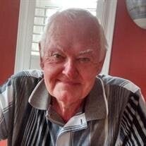Elderly man smiling in casual shirt indoors.