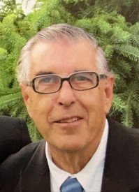 Smiling man in glasses with greenery background