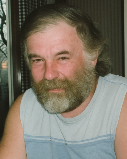 Smiling man with beard in casual wear indoors.