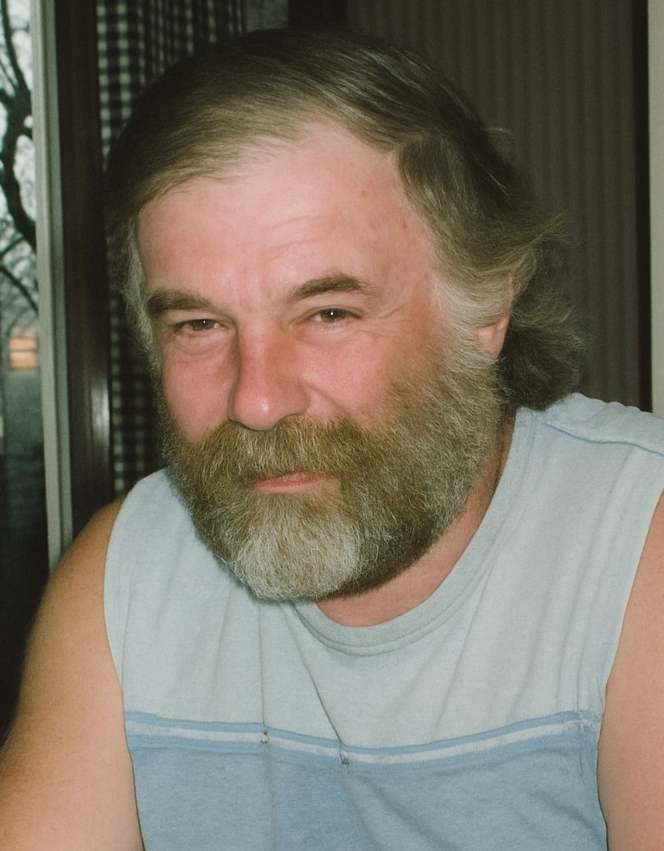DONNERAL, Gilbert Wesley Donneral Smiling man with beard in casual wear indoors.