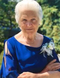 Elderly woman in blue dress, smiling outdoors
