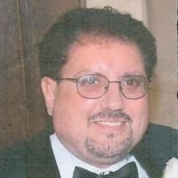 Man in formal attire smiling at event.