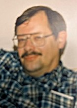Person wearing glasses and plaid shirt smiling