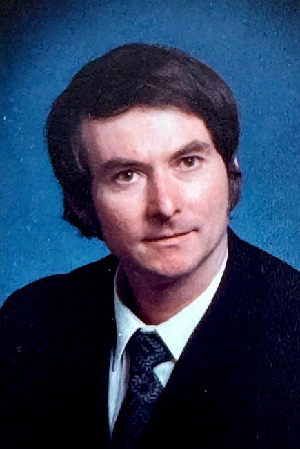 Portrait of a man in suit, blue background.