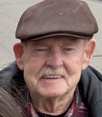 Elderly man wearing a hat, smiling outdoors.