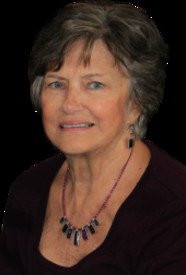 Smiling woman with short hair and necklace.