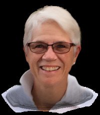 Smiling person with short white hair and glasses