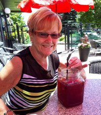 Woman enjoying a drink outdoors at a cafe.