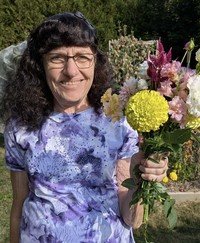 Smiling woman holding colorful bouquet outdoors.
