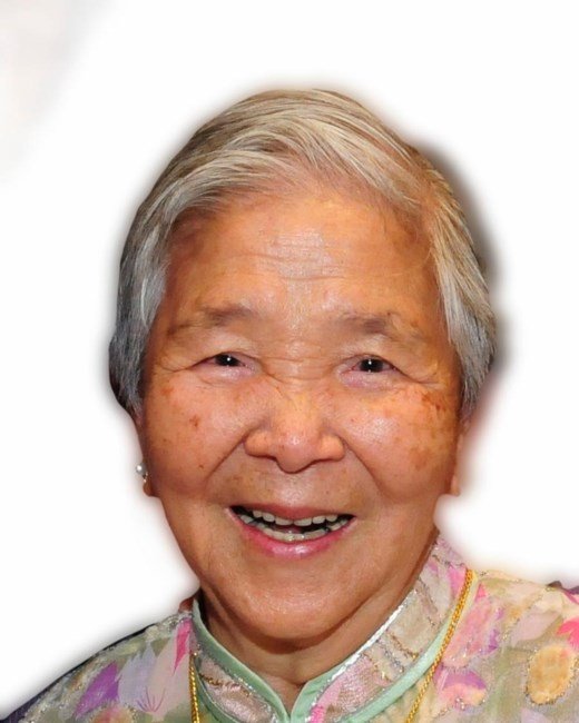 Smiling elderly person with short gray hair.