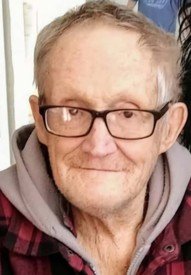 Elderly man with glasses, beard, wearing a hoodie.