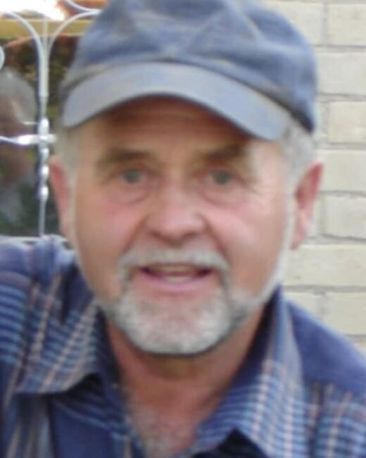 Older man with cap and beard smiling outdoors
