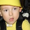 Child wearing yellow outfit and helmet close-up