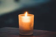 Lit candle in dark room for relaxation ambiance.