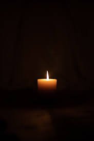 Single candle flame in darkness.