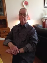 KELL, John Laurie Kell Man sitting at dining table, casual home atmosphere.