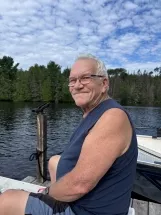 Smiling man sitting by the lake