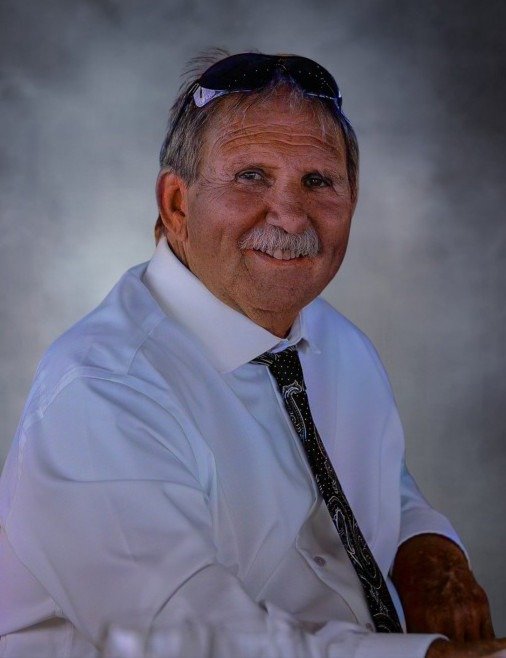 Smiling man in white shirt with sunglasses.
