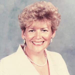 Smiling person in suit with pearl necklace