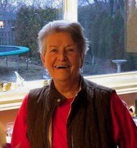 Smiling person standing indoors by window