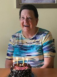 Smiling woman with birthday cake and candles.
