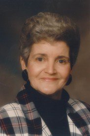 Smiling woman in plaid jacket portrait.