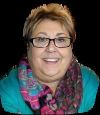 Smiling person wearing glasses and a colorful scarf.