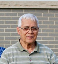 Older man wearing glasses, striped shirt, outdoors