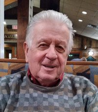 Elderly man smiling in a restaurant setting.