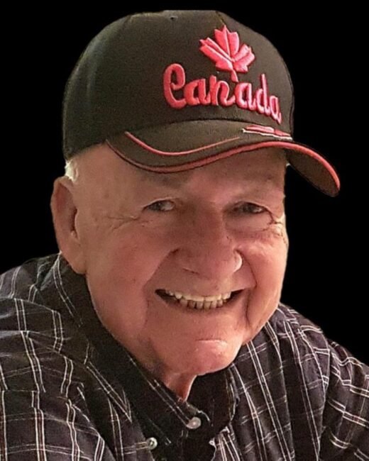 Smiling man wearing Canada cap and checkered shirt.