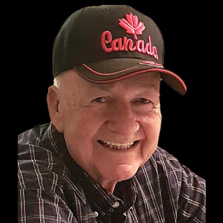 Smiling man wearing Canada cap and checkered shirt.