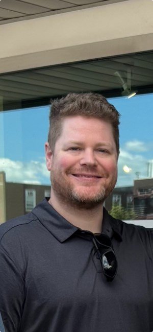 Smiling person outside in casual attire