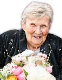 Elderly woman smiling with colorful flower bouquet.