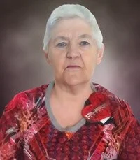 Elderly woman with short white hair, wearing red sweater.