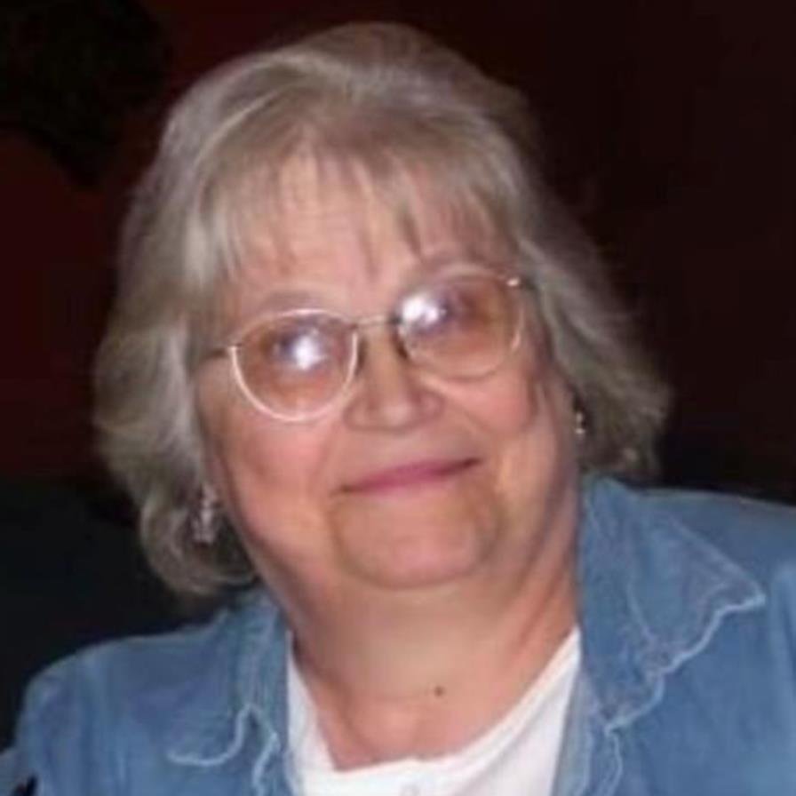 Smiling woman with glasses and denim shirt