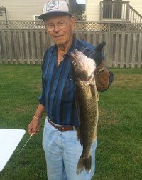 Man holding large fish in backyard.