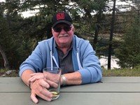Man smiling outdoors with drink in hand