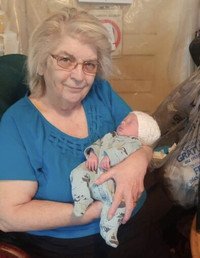Elderly woman holding a newborn baby