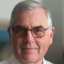 Smiling person wearing glasses and a white shirt