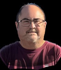 Smiling person wearing glasses and a maroon shirt.