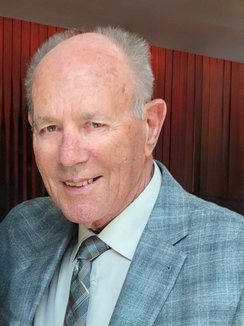 Smiling man in suit with wood background.