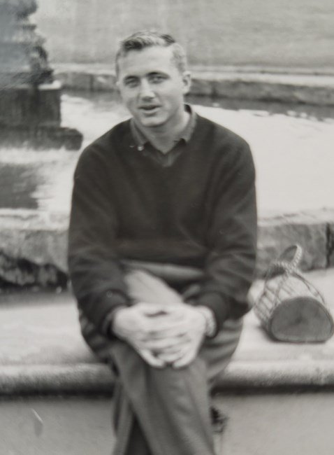 Man sitting by a fountain, holding hands
