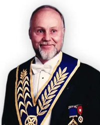 Man in ceremonial attire with medals and ribbon.