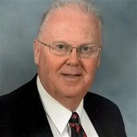Elderly man in suit and tie smiling